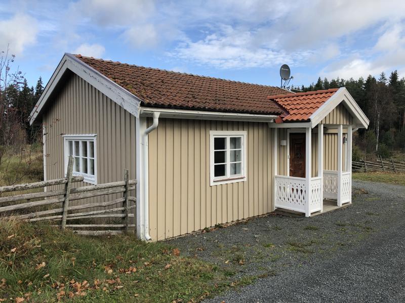 Stugan från framsidan, med grusgång och gärdesgård